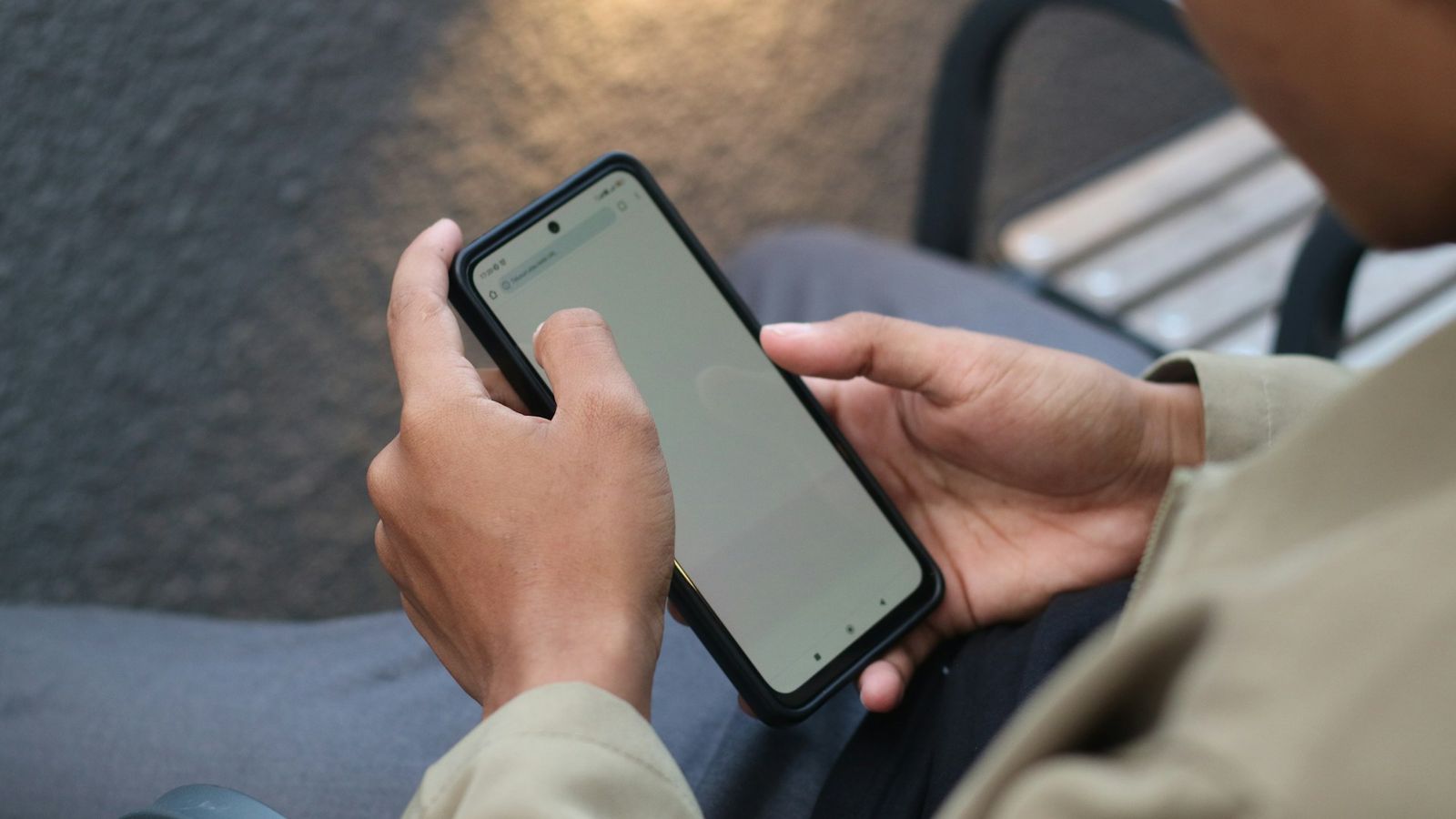 Un líder de iglesia leyendo en su teléfono un mensaje de la comunidad